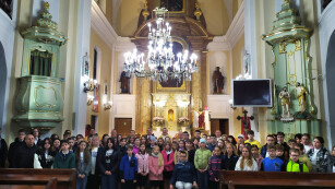 Grupa około 60 uczniów -uczestników konkursu, na tle ołtarza kościoła w Sernikach.