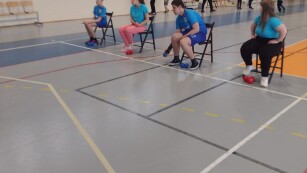 Para chłopców i para dziewcząt siedzą na przemian na krzesłach