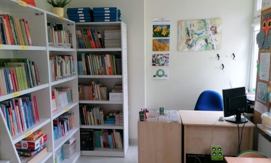 Fotografia biblioteki SPS 26 na ul. Kurantowej. Widać na niej półki z książkami oraz biurko pani bibliotekarki